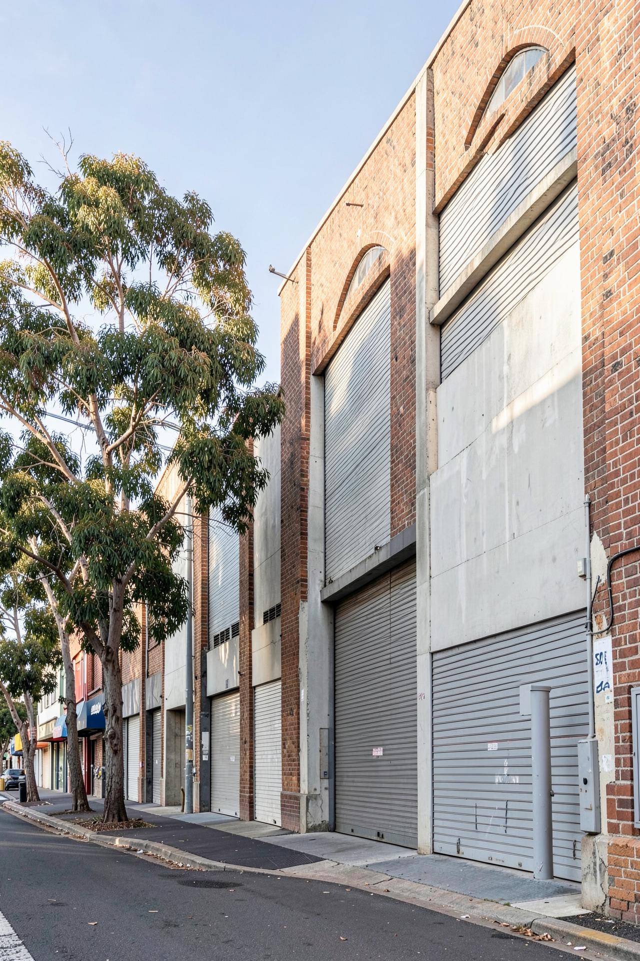 A row of mixed commercial and light industrial facades along a quiet urban street